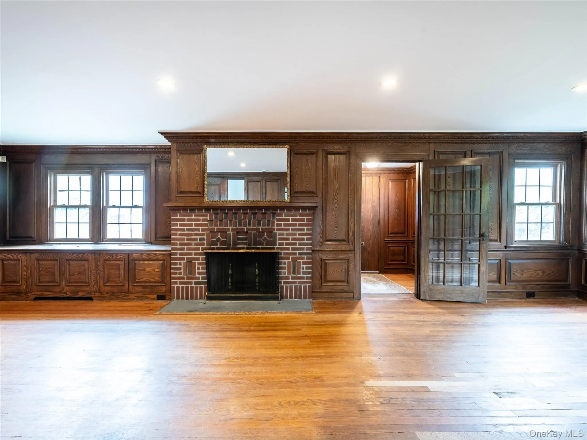 Unfurnished living room featuring ornamental molding, wood-type flooring, plenty of natural light, a fireplace, and recessed lighting Unfurnished living room featuring ornamental molding, wood-type flooring, plenty of natural light, a fireplace, and recessed lighting