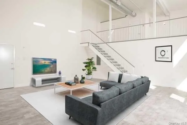 Living area featuring a towering ceiling and stairs Living area featuring a towering ceiling and stairs