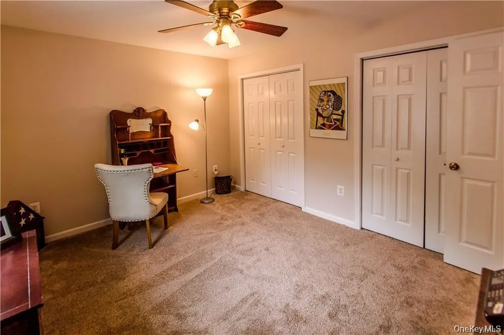 Home office featuring light carpet and a ceiling fan Home office featuring light carpet and a ceiling fan