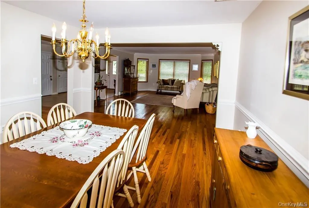 Dining space featuring a chandelier, dark wood finished floors, baseboard heating, and ornamental molding Dining space featuring a chandelier, dark wood finished floors, baseboard heating, and ornamental molding