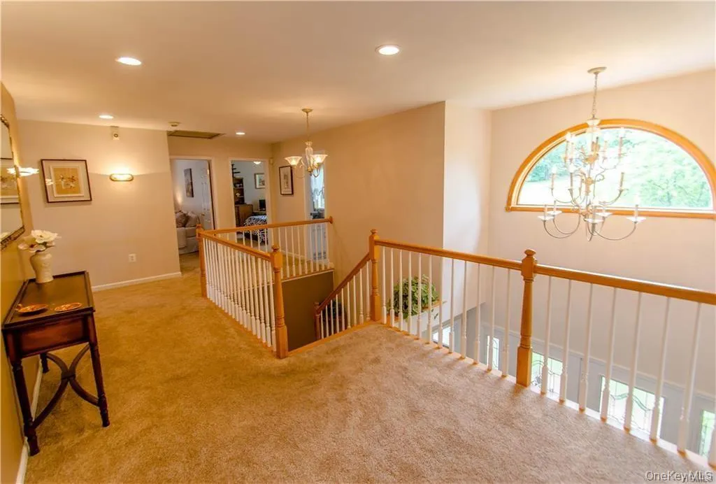 Hall featuring a chandelier, recessed lighting, an upstairs landing, and carpet flooring Hall featuring a chandelier, recessed lighting, an upstairs landing, and carpet flooring