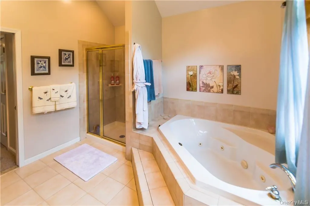 Full bath with a stall shower, tile patterned floors, and a whirlpool tub Full bath with a stall shower, tile patterned floors, and a whirlpool tub