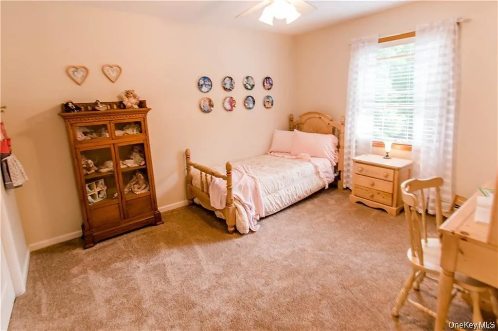 Bedroom featuring light carpet and a ceiling fan Bedroom featuring light carpet and a ceiling fan