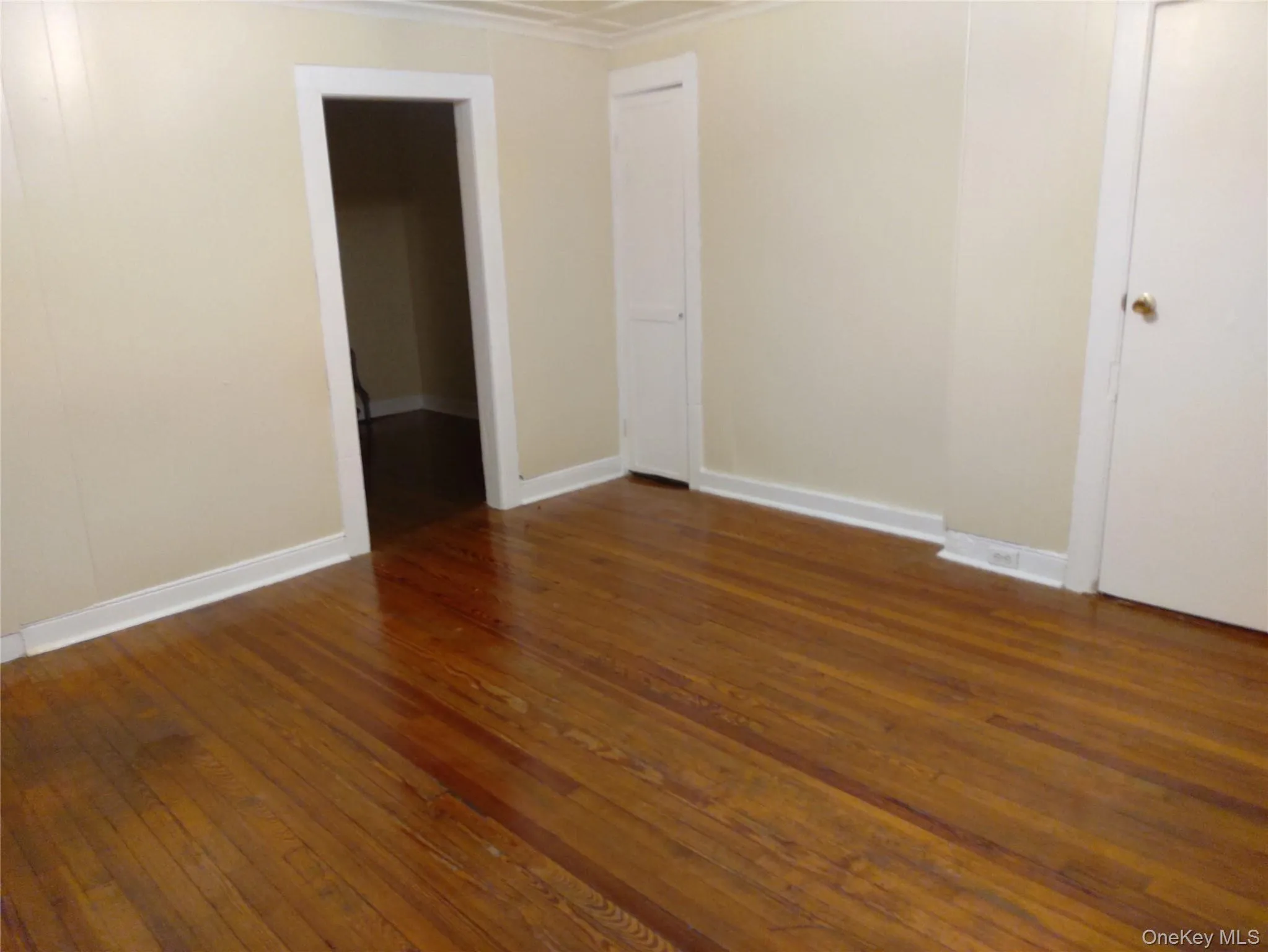 Empty room with dark wood finished floors and baseboards Empty room with dark wood finished floors and baseboards
