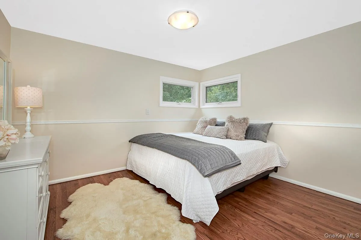 Bedroom with dark wood-type flooring and baseboards Bedroom with dark wood-type flooring and baseboards