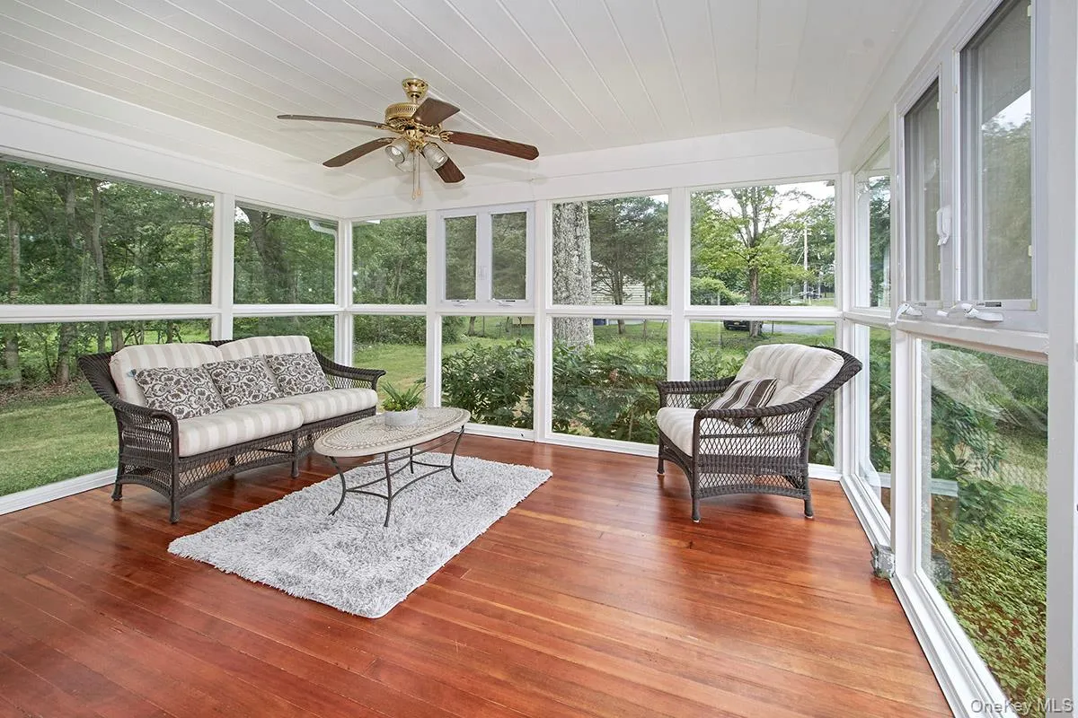 Sunroom featuring an outdoor hangout area, a ceiling fan, lofted ceiling, and view of scattered trees Sunroom featuring an outdoor hangout area, a ceiling fan, lofted ceiling, and view of scattered trees