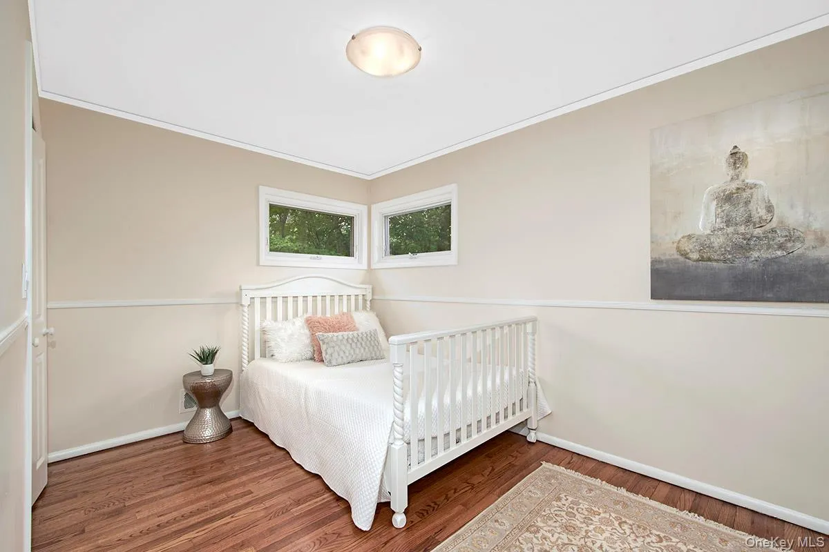 Bedroom featuring dark wood-style floors and ornamental molding Bedroom featuring dark wood-style floors and ornamental molding