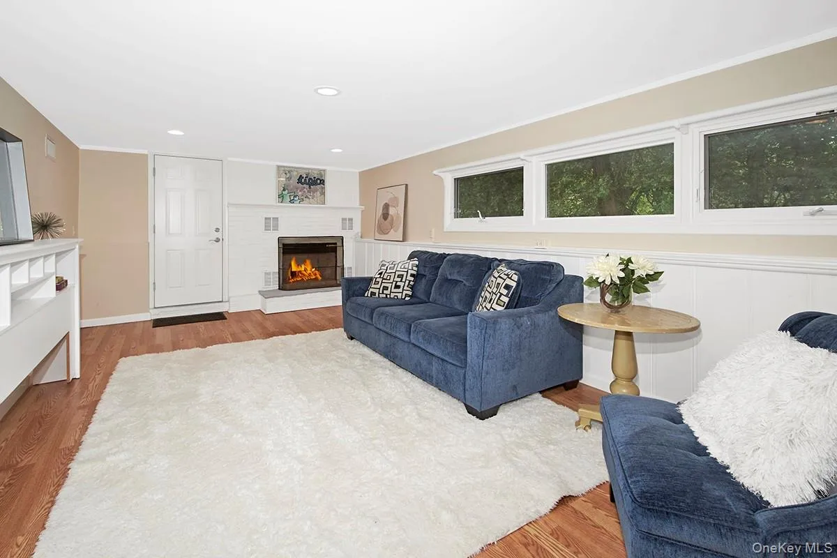 Living area featuring wood finished floors, recessed lighting, a glass covered fireplace, and crown molding Living area featuring wood finished floors, recessed lighting, a glass covered fireplace, and crown molding