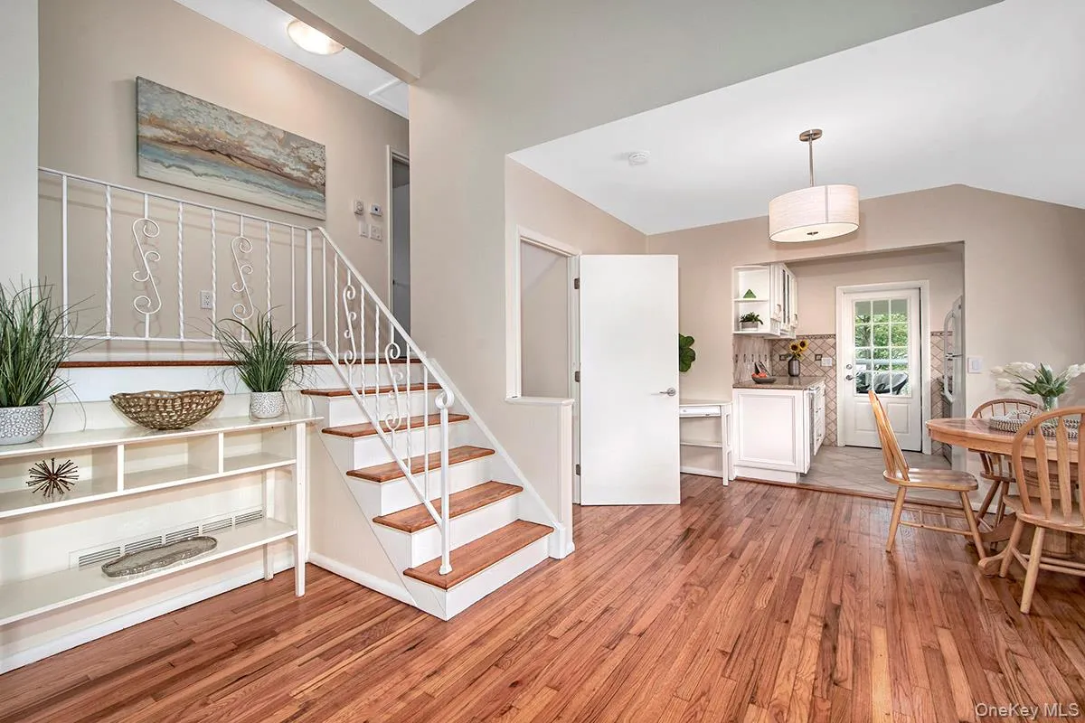 Stairs featuring wood finished floors and vaulted ceiling Stairs featuring wood finished floors and vaulted ceiling
