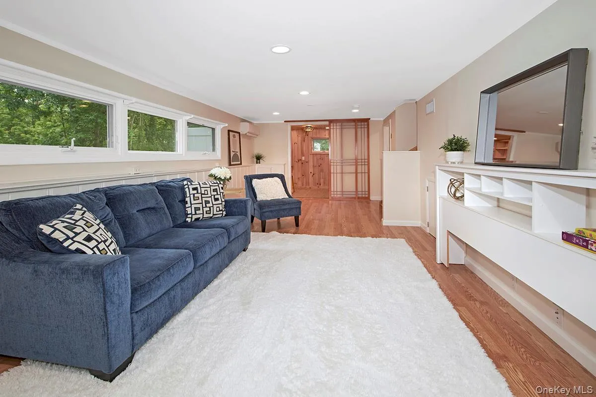 Living area with light wood-style flooring, recessed lighting, and a wall unit AC Living area with light wood-style flooring, recessed lighting, and a wall unit AC