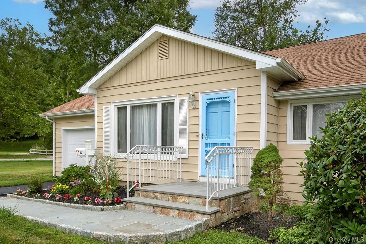 View of exterior entry featuring a shingled roof, a garage, and a yard View of exterior entry featuring a shingled roof, a garage, and a yard