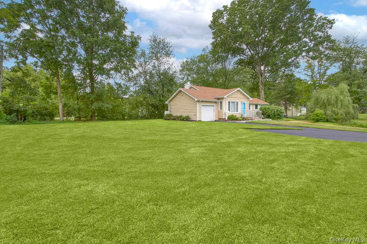 Ranch-style home featuring asphalt driveway and a front lawn Ranch-style home featuring asphalt driveway and a front lawn