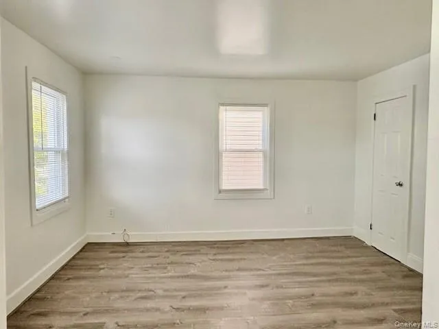 Empty room with light wood-style floors and baseboards Empty room with light wood-style floors and baseboards