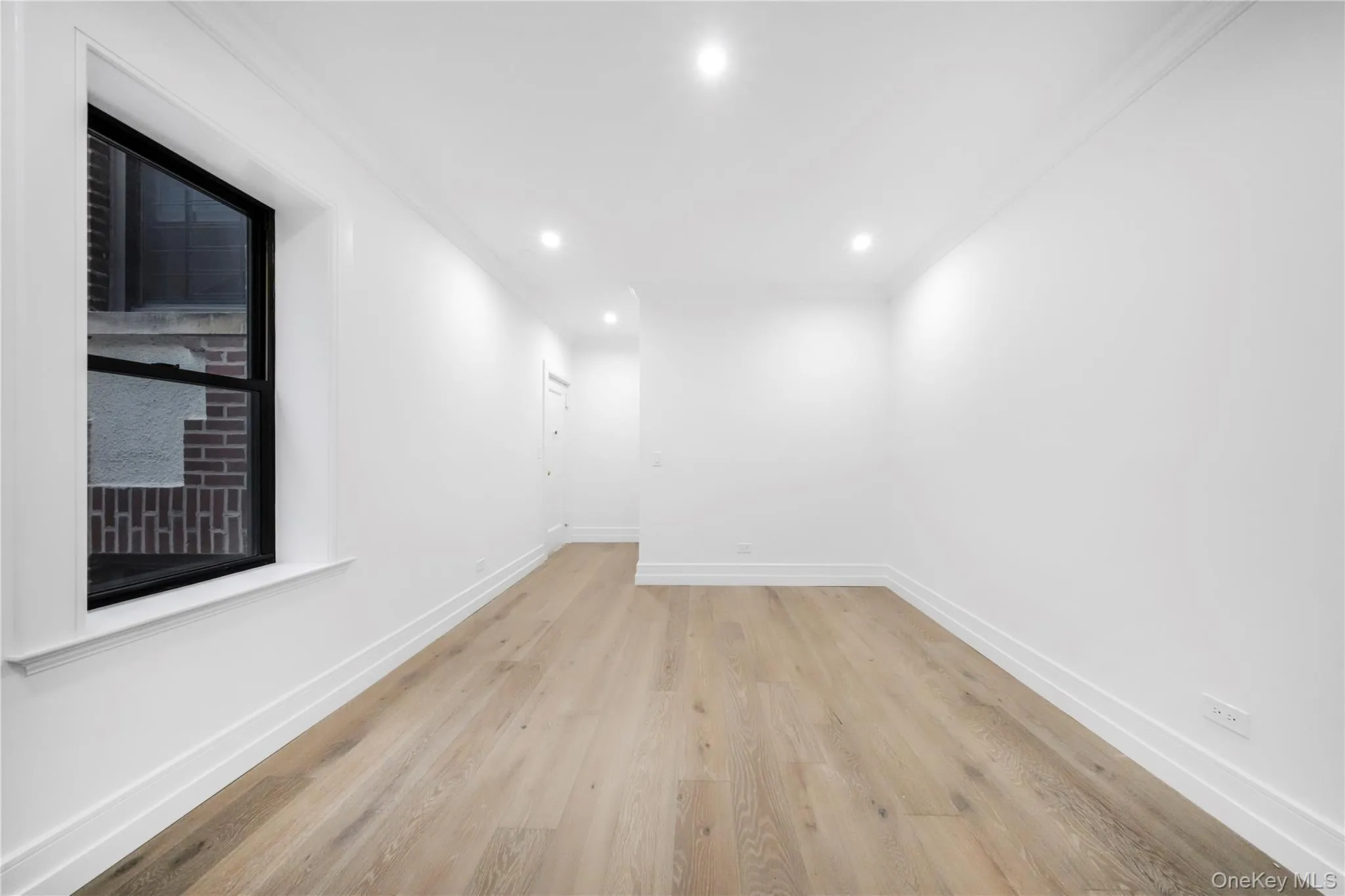 Unfurnished room with ornamental molding, light wood-style floors, and recessed lighting Unfurnished room with ornamental molding, light wood-style floors, and recessed lighting