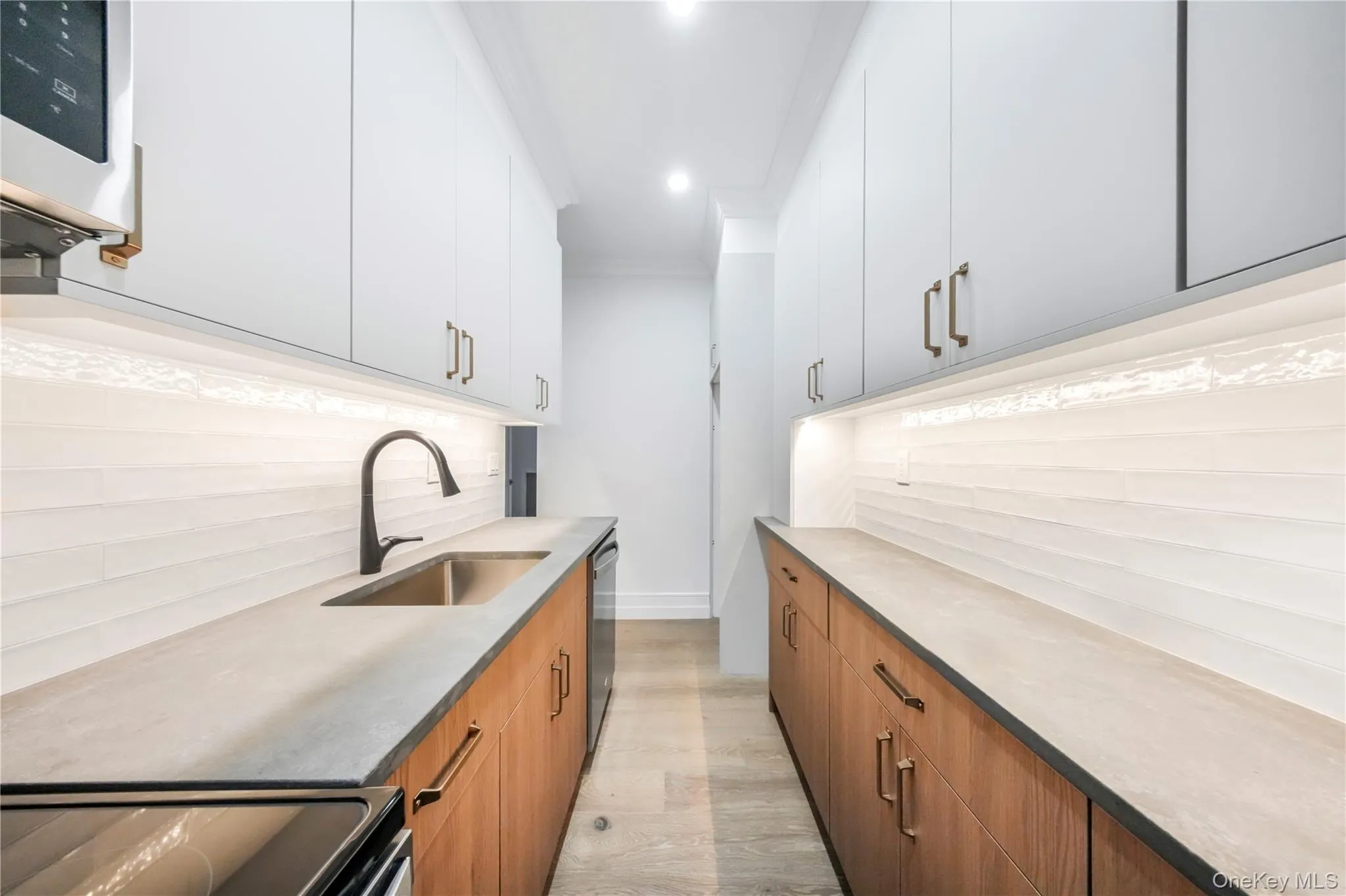 Kitchen with appliances with stainless steel finishes, decorative backsplash, light stone counters, brown cabinetry, and recessed lighting Kitchen with appliances with stainless steel finishes, decorative backsplash, light stone counters, brown cabinetry, and recessed lighting
