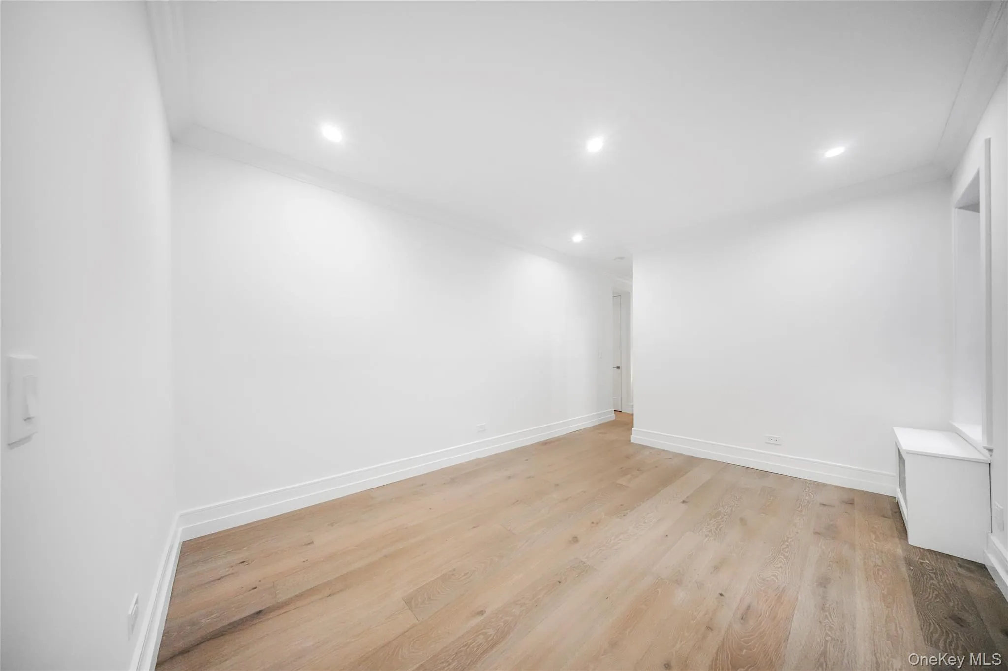 Unfurnished room with light wood finished floors, crown molding, and recessed lighting Unfurnished room with light wood finished floors, crown molding, and recessed lighting