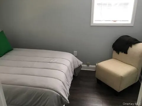 Bedroom with dark wood-style floors and baseboards Bedroom with dark wood-style floors and baseboards