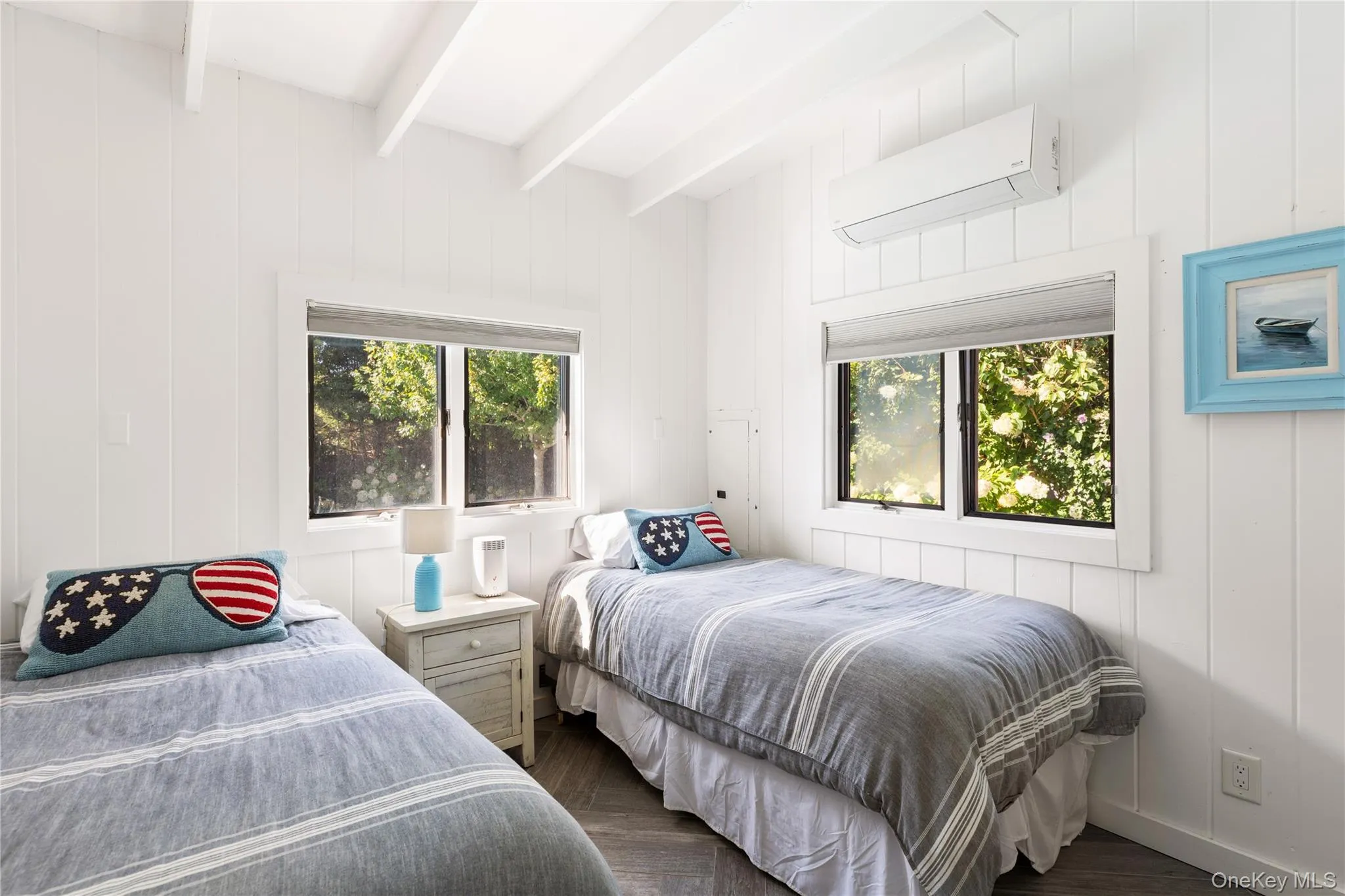 Bedroom featuring a wall mounted air conditioner, dark wood-type flooring, and beamed ceiling Bedroom featuring a wall mounted air conditioner, dark wood-type flooring, and beamed ceiling