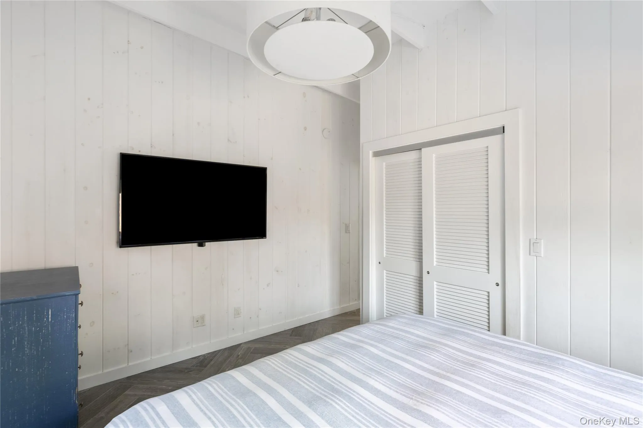 Bedroom featuring wood walls and a closet Bedroom featuring wood walls and a closet