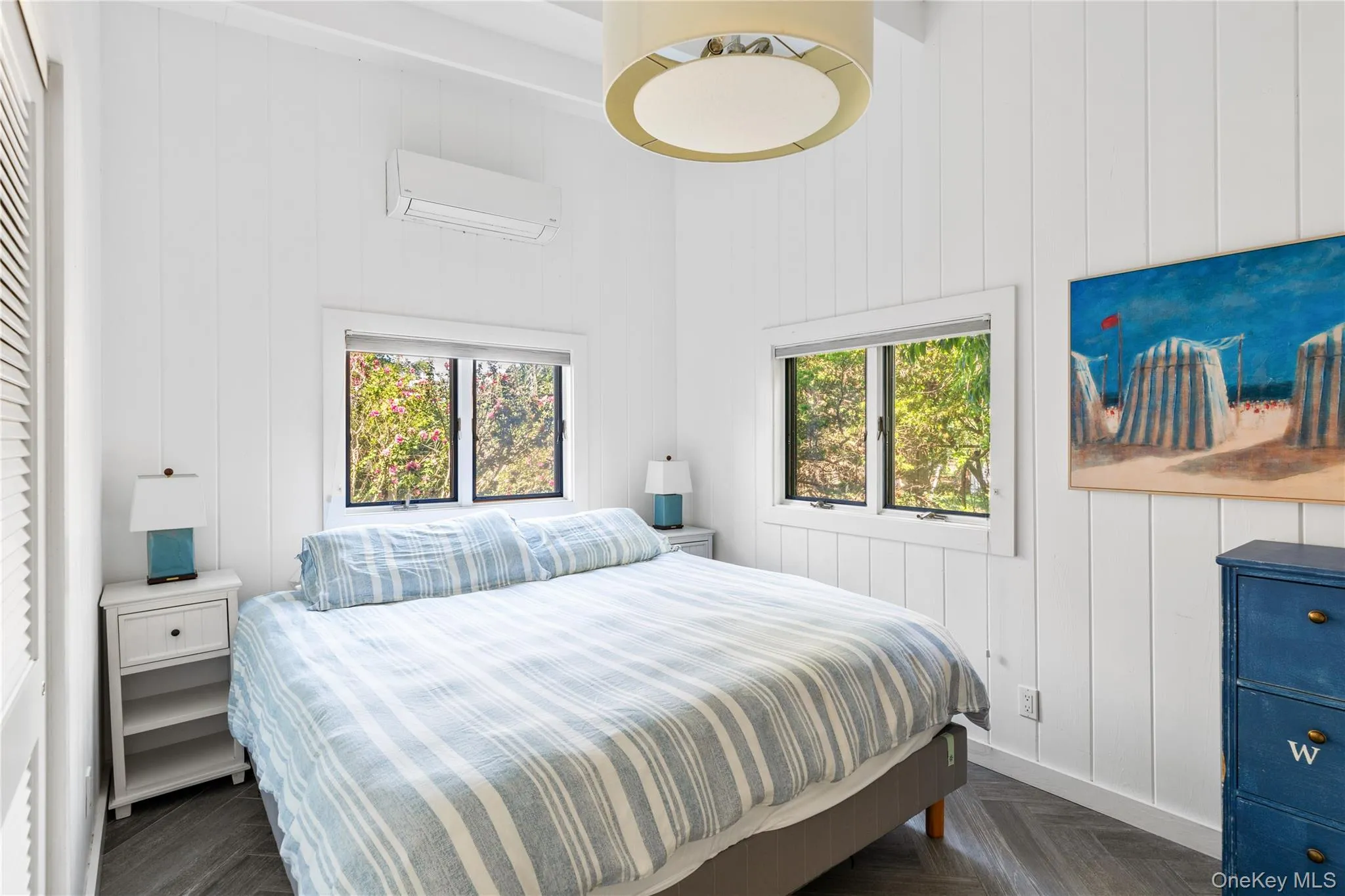 Bedroom featuring a wall mounted AC, a high ceiling, and wooden walls Bedroom featuring a wall mounted AC, a high ceiling, and wooden walls