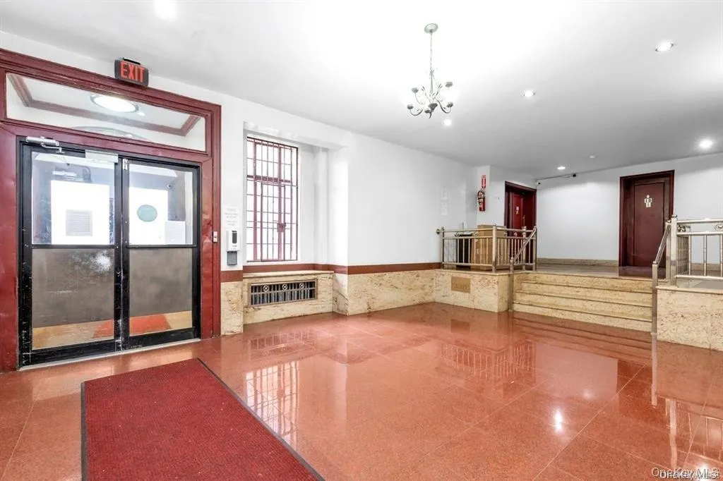Community lobby with recessed lighting, stairs, wainscoting, and tile walls Community lobby with recessed lighting, stairs, wainscoting, and tile walls