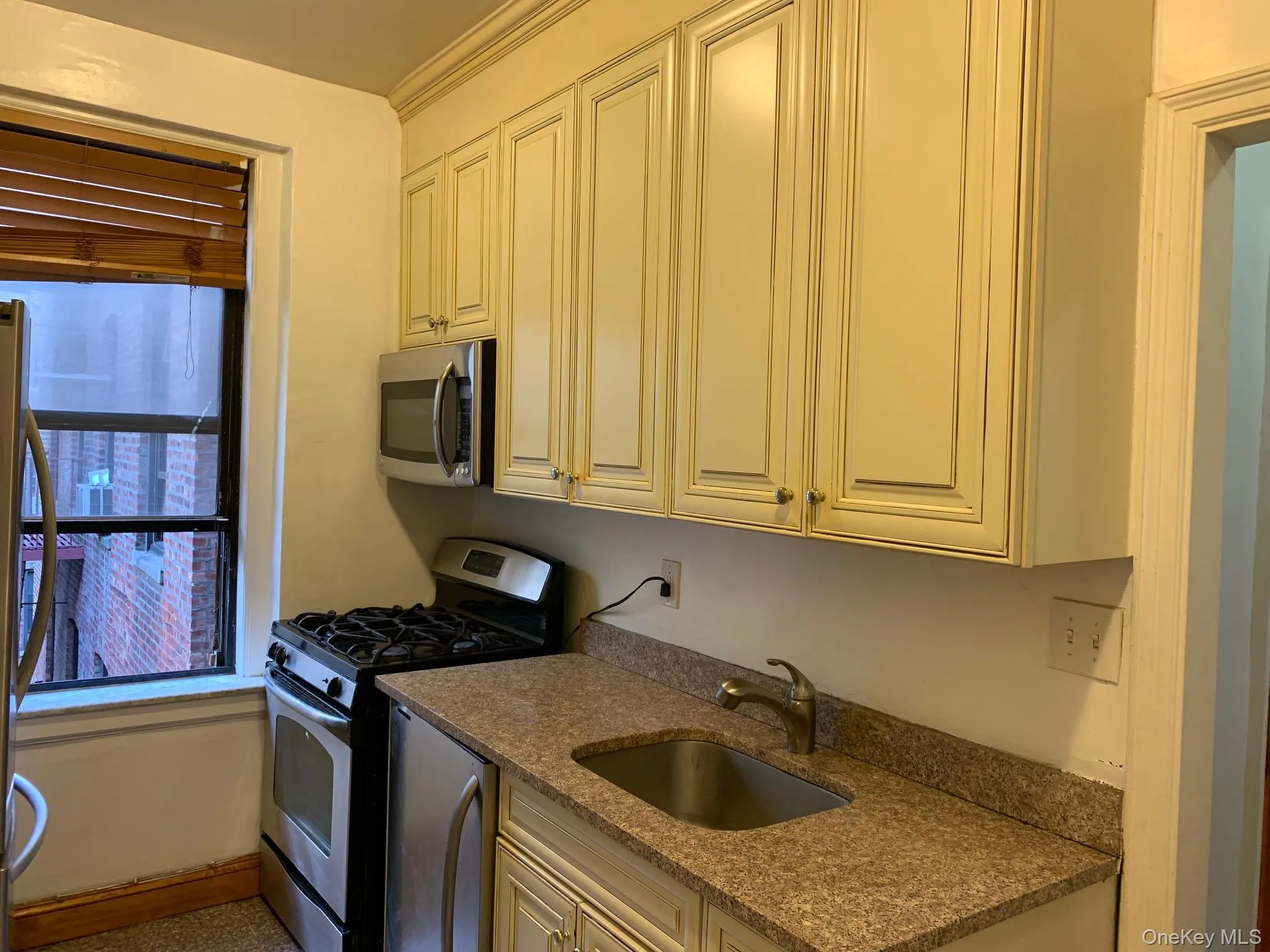 Kitchen featuring appliances with stainless steel finishes and dark stone counters Kitchen featuring appliances with stainless steel finishes and dark stone counters