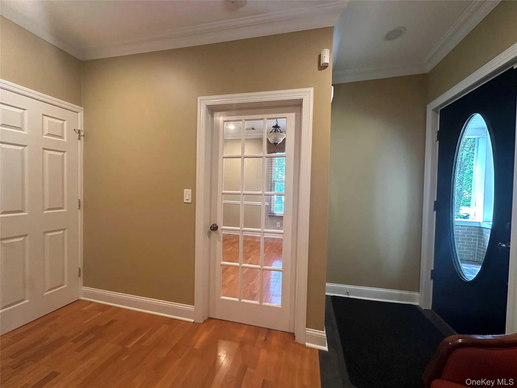 Entryway featuring wood finished floors and crown molding Entryway featuring wood finished floors and crown molding