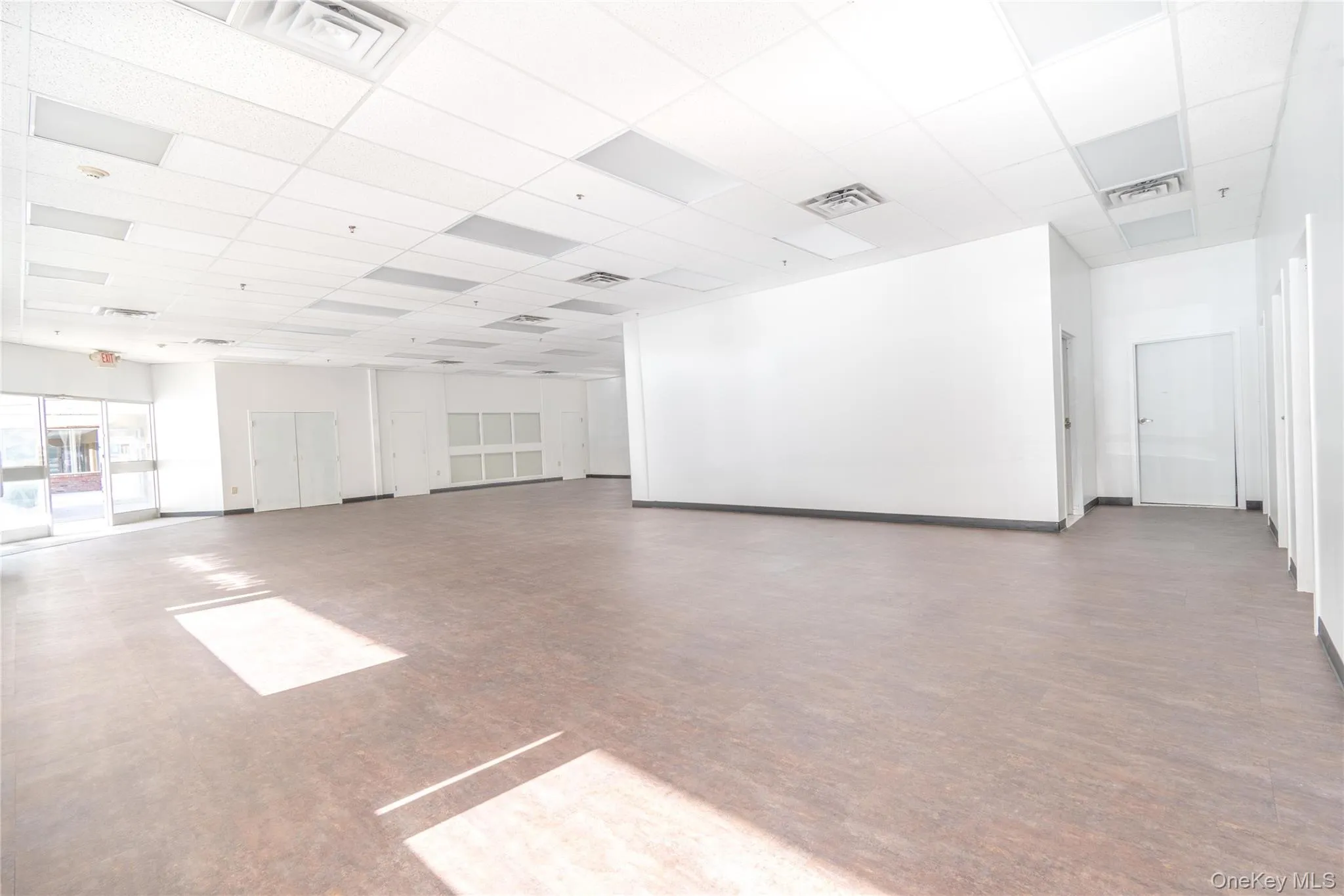 Empty room with a paneled ceiling and baseboards Empty room with a paneled ceiling and baseboards