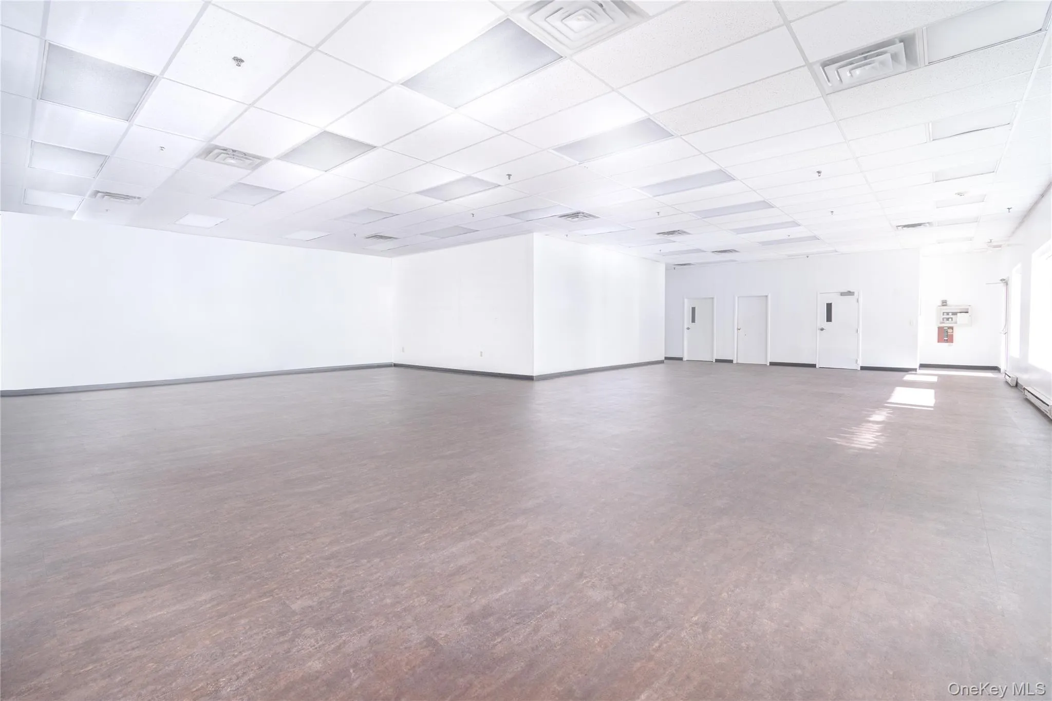 Spare room with a drop ceiling and baseboards Spare room with a drop ceiling and baseboards