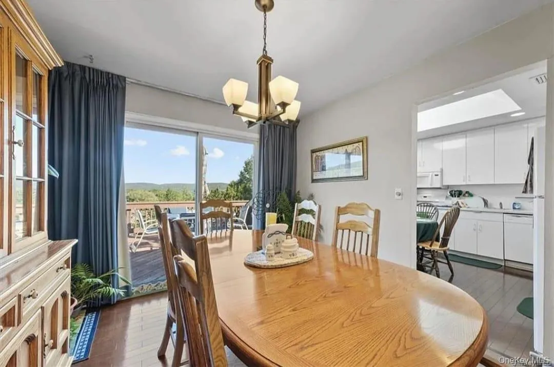 Dining room with a chandelier and dark wood finished floors Dining room with a chandelier and dark wood finished floors