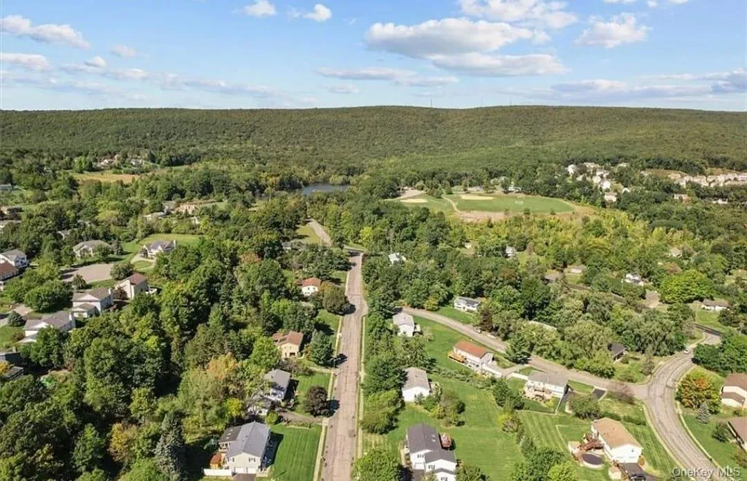 Aerial view of property and surrounding area with a heavily wooded area Aerial view of property and surrounding area with a heavily wooded area