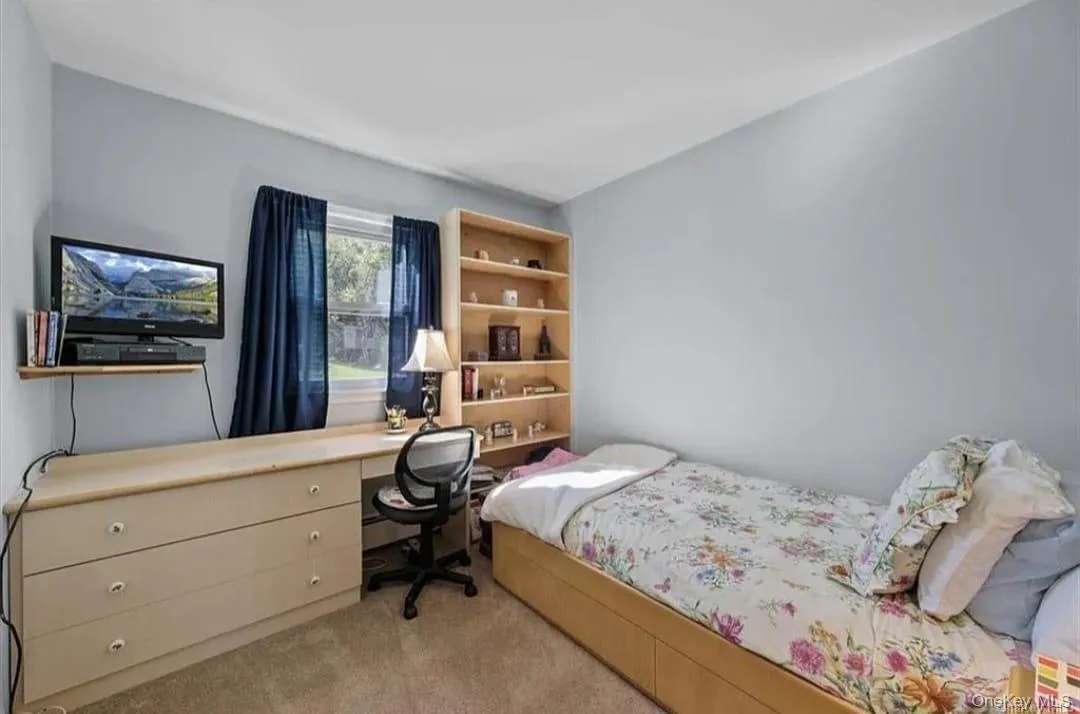 Bedroom with light colored carpet and a desk Bedroom with light colored carpet and a desk