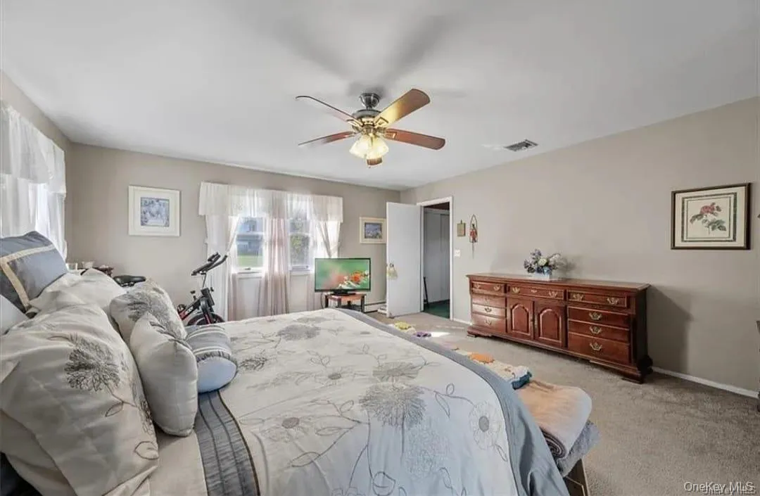 Bedroom with light colored carpet and ceiling fan Bedroom with light colored carpet and ceiling fan