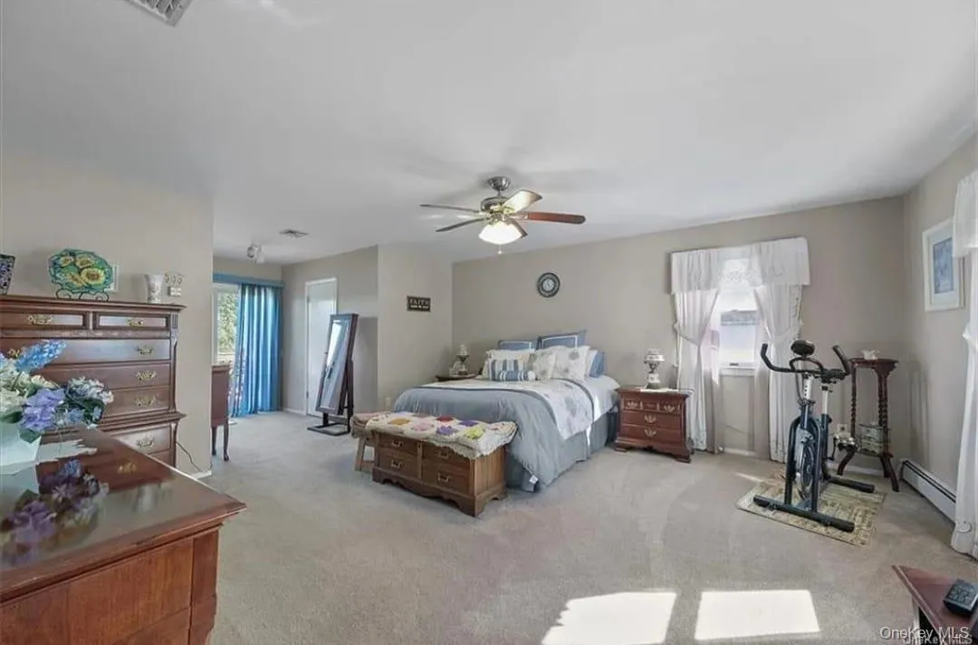 Bedroom with light carpet, multiple windows, and ceiling fan Bedroom with light carpet, multiple windows, and ceiling fan