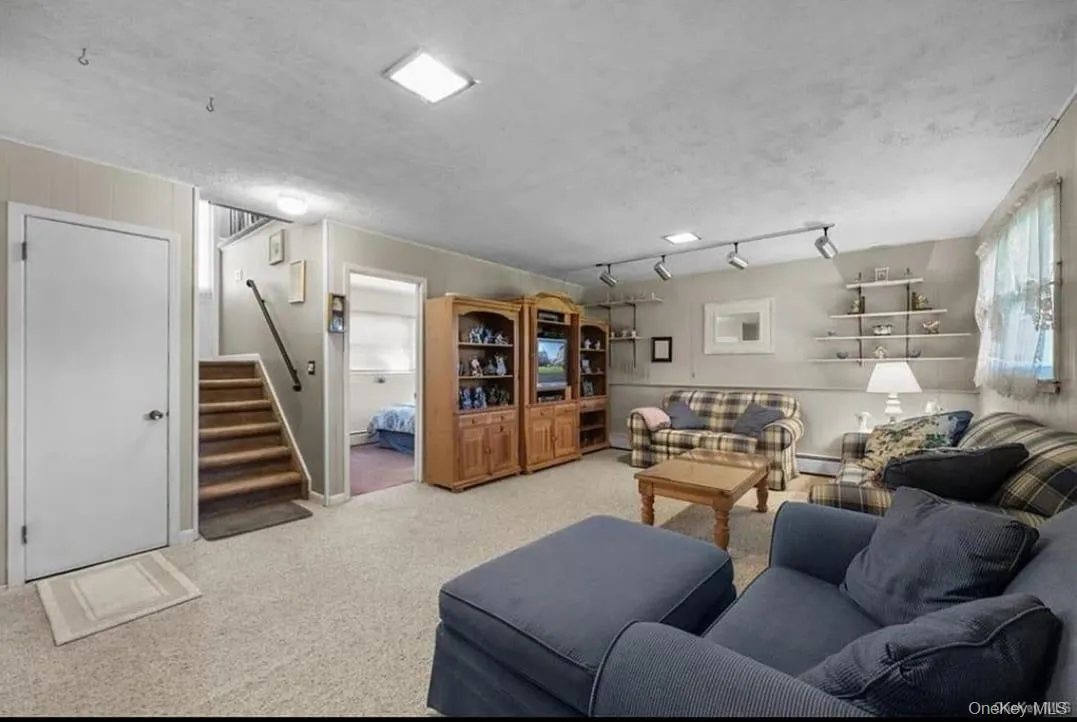 Carpeted living area featuring stairway Carpeted living area featuring stairway