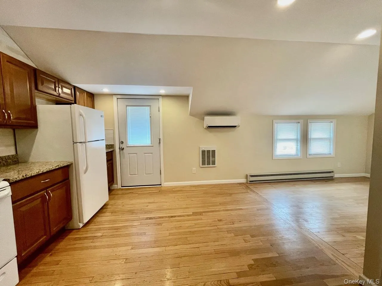 Kitchen with plenty of natural light, white appliances, light wood-style floors, recessed lighting, and light stone countertops Kitchen with plenty of natural light, white appliances, light wood-style floors, recessed lighting, and light stone countertops