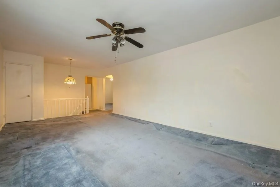 Carpeted empty room featuring baseboards and a ceiling fan Carpeted empty room featuring baseboards and a ceiling fan