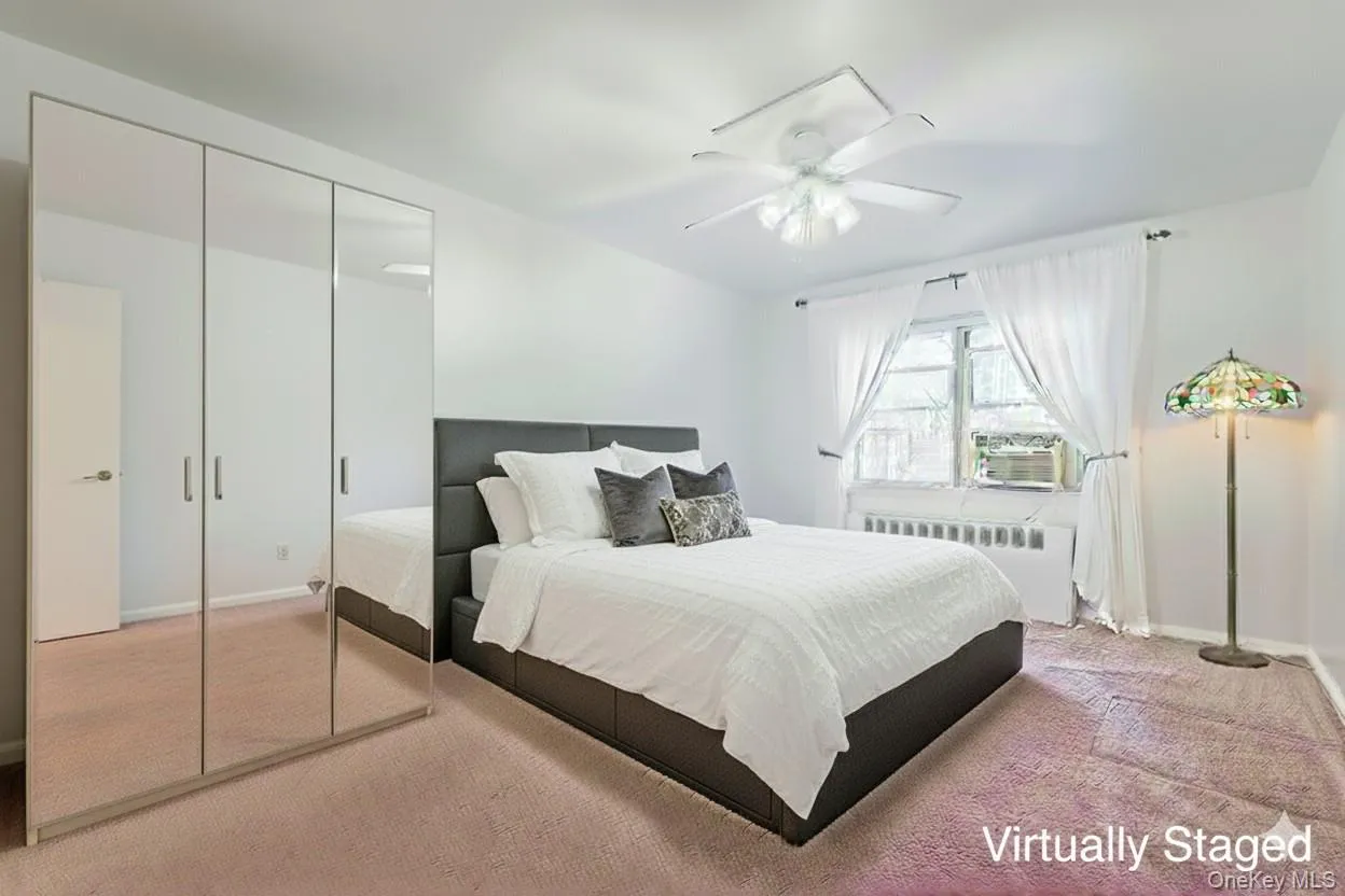 Carpeted bedroom featuring radiator, ceiling fan, and a closet Carpeted bedroom featuring radiator, ceiling fan, and a closet