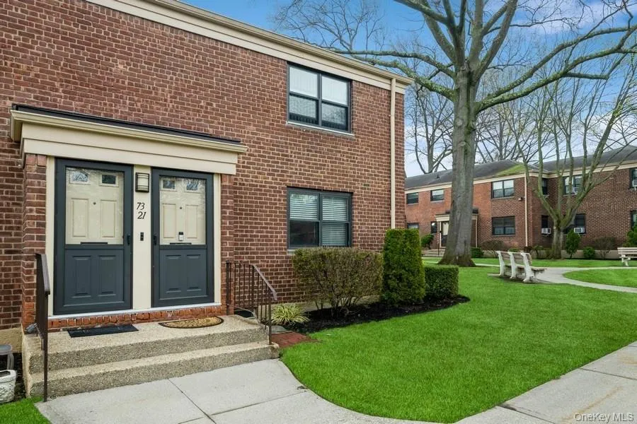 Entrance to property featuring brick siding and a lawn Entrance to property featuring brick siding and a lawn