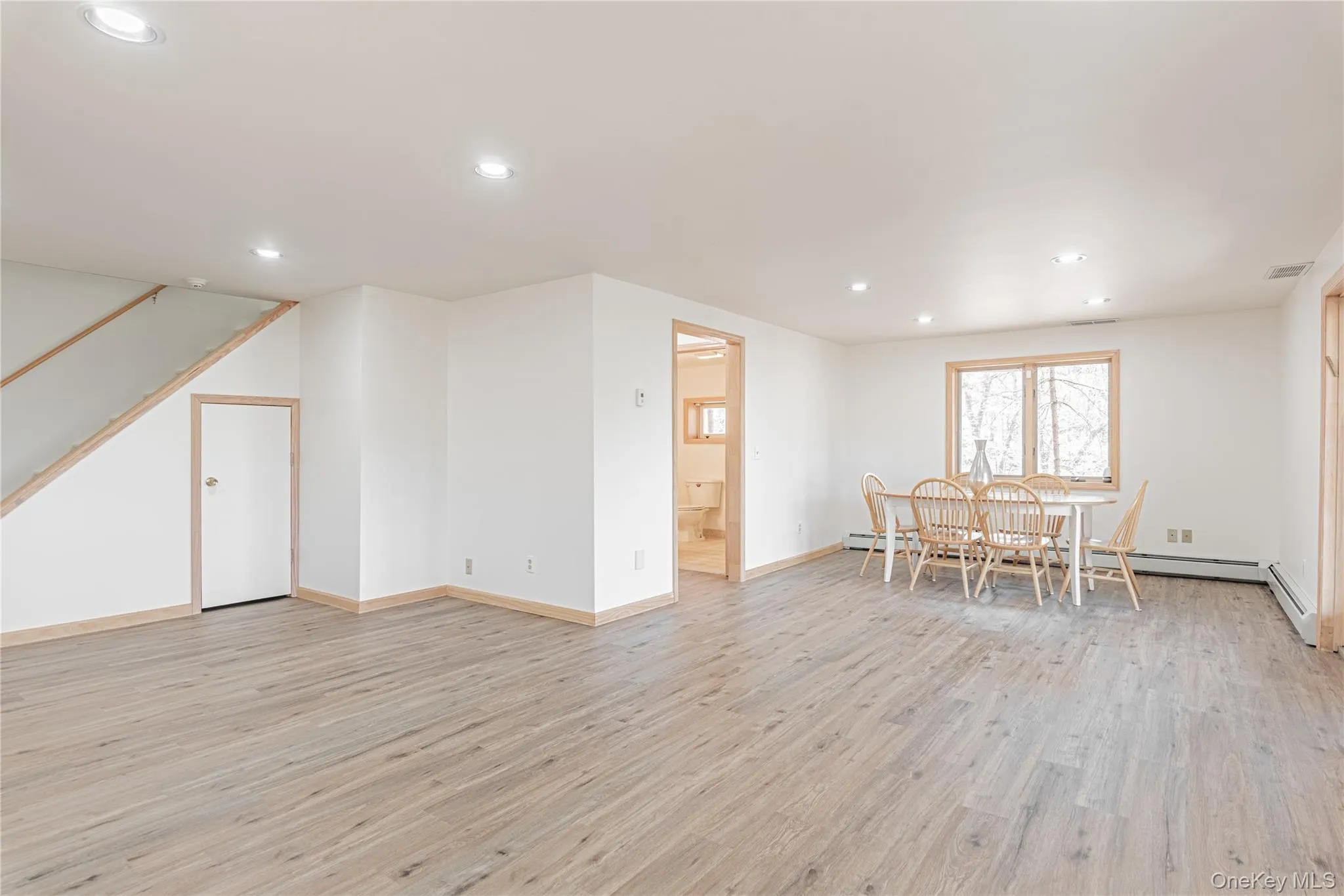 Living area with recessed lighting, light wood finished floors, and stairway Living area with recessed lighting, light wood finished floors, and stairway