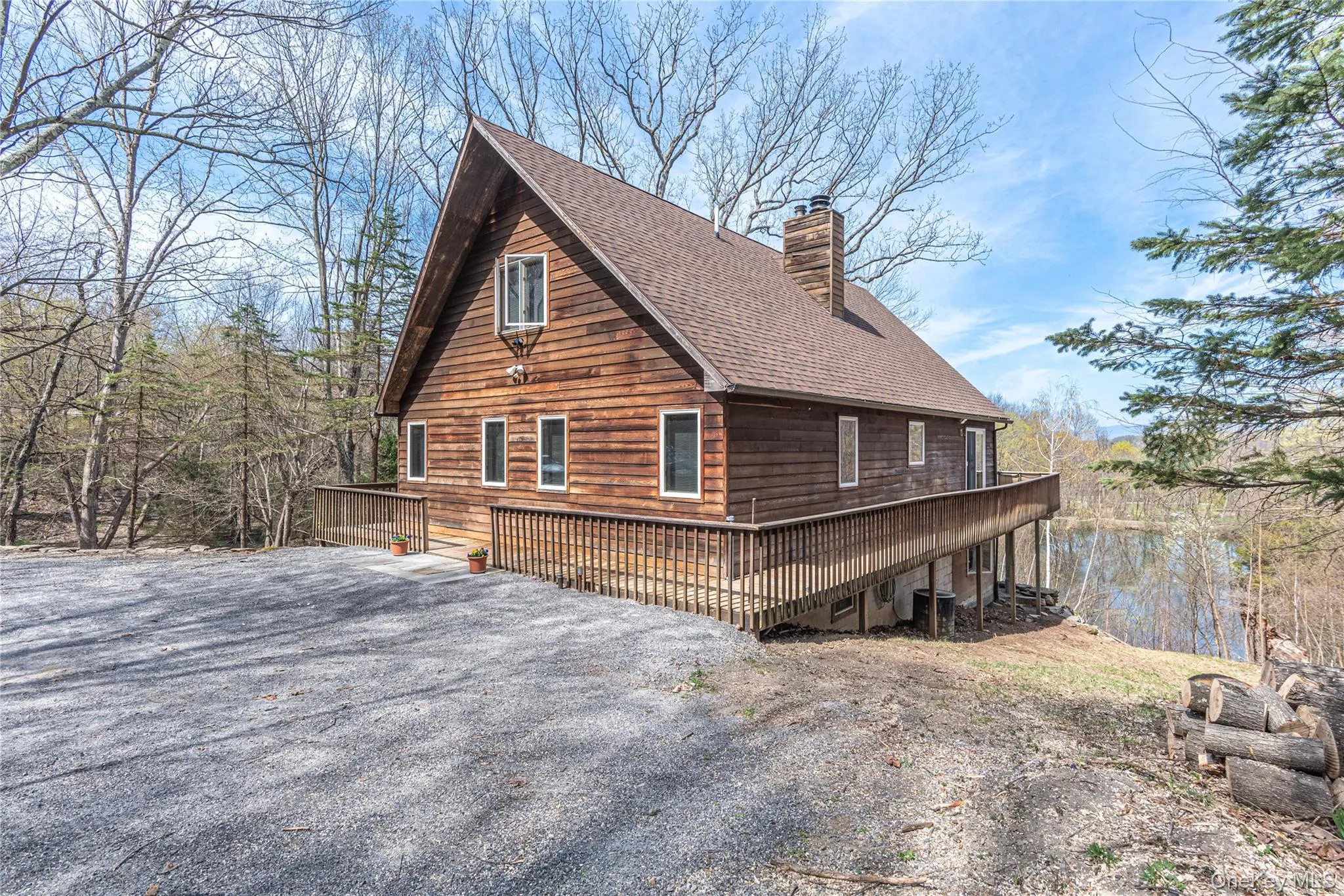 View of side of home with a wooden deck, a chimney, and a shingled roof View of side of home with a wooden deck, a chimney, and a shingled roof