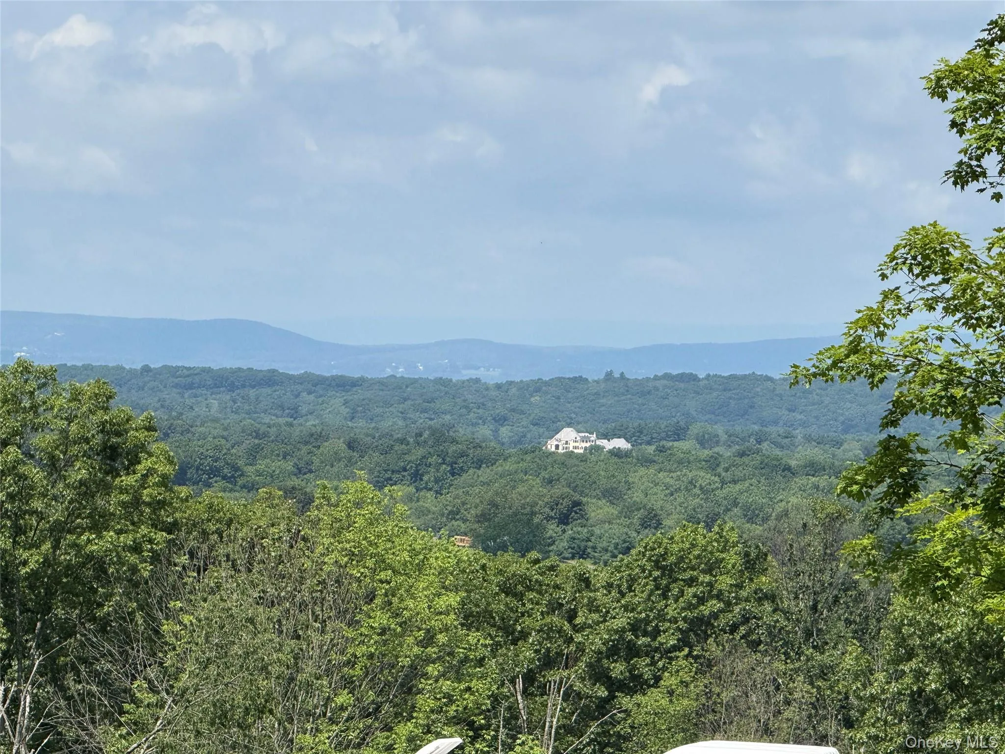 View of mountain backdrop featuring a forest View of mountain backdrop featuring a forest