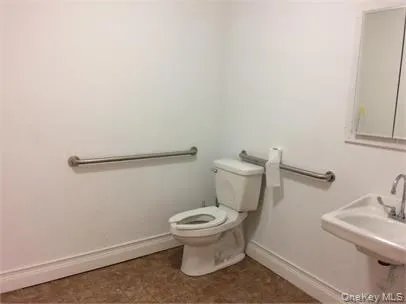 Half bathroom featuring toilet and baseboards Half bathroom featuring toilet and baseboards