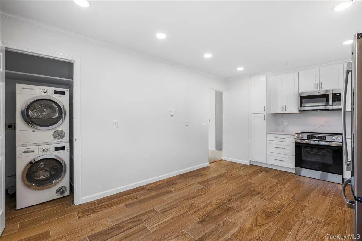 Kitchen view towards entrance featuring the in unit washer and dryer. Kitchen view towards entrance featuring the in unit washer and dryer.