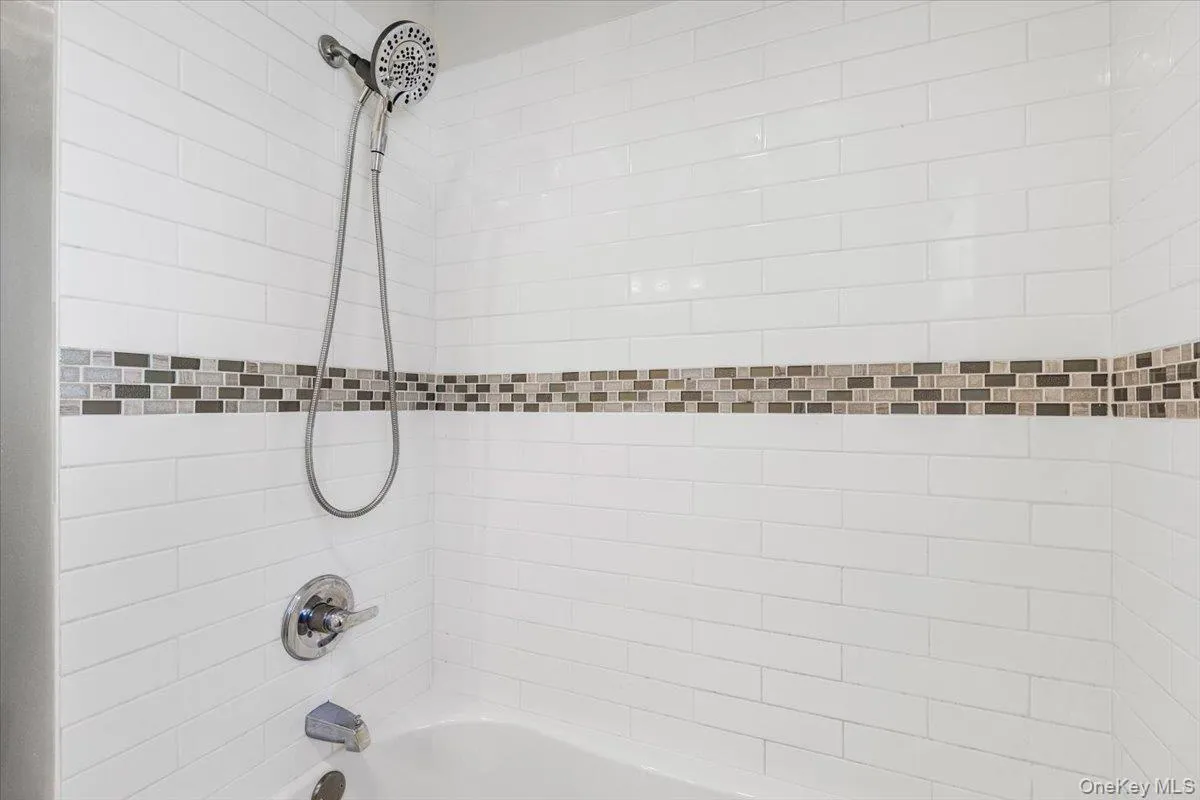 Bathroom view of bathtub / shower combination. Bathroom view of bathtub / shower combination.