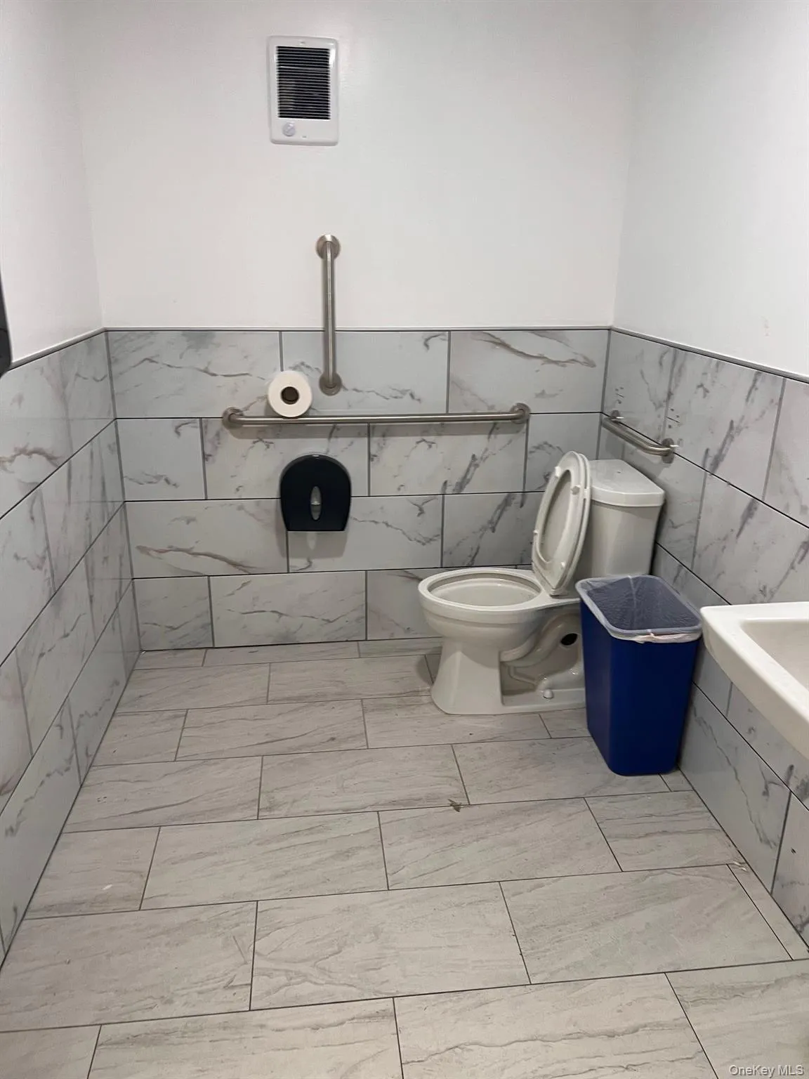 Full bath featuring tile walls, wainscoting, and tiled bath Full bath featuring tile walls, wainscoting, and tiled bath