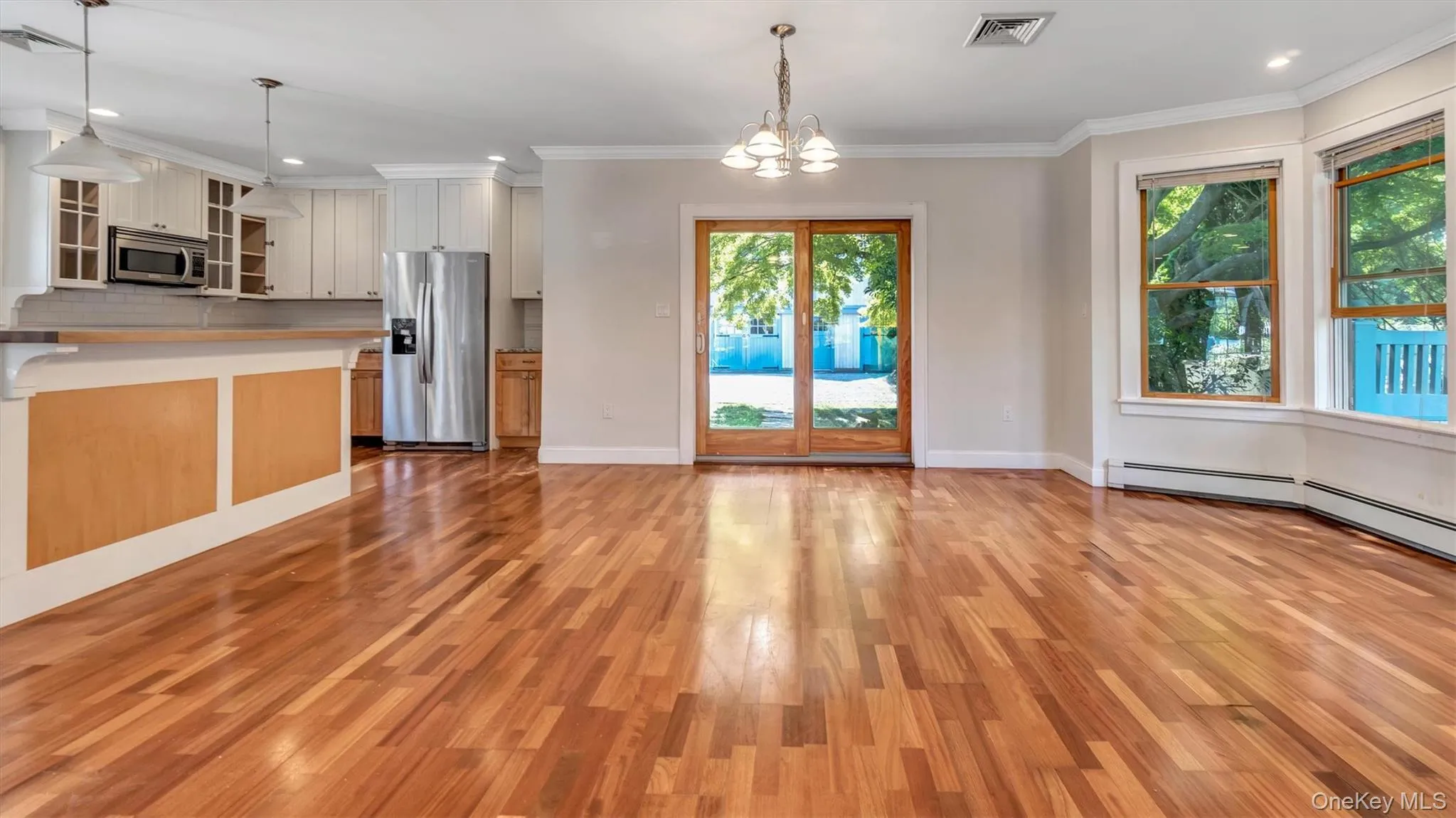 Kitchen featuring stainless steel appliances, hanging light fixtures, recessed lighting, glass insert cabinets, and a chandelier Kitchen featuring stainless steel appliances, hanging light fixtures, recessed lighting, glass insert cabinets, and a chandelier