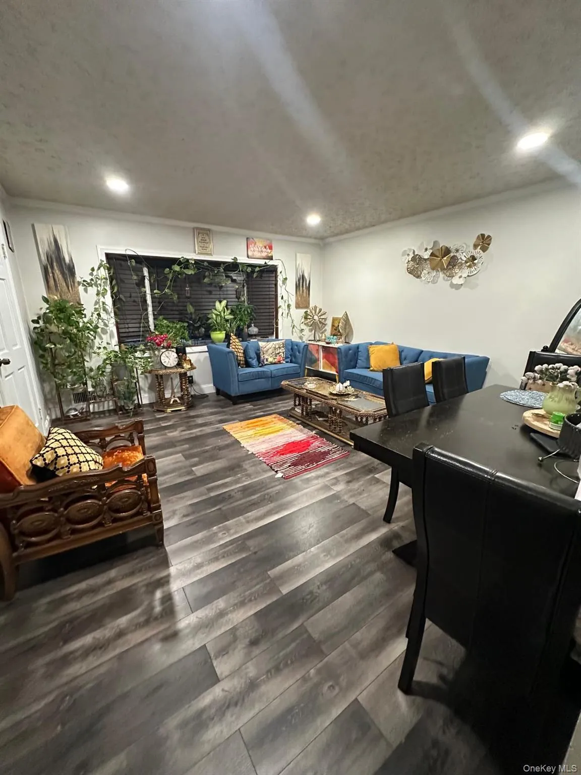 Living room featuring dark wood finished floors, recessed lighting, ornamental molding, and a textured ceiling Living room featuring dark wood finished floors, recessed lighting, ornamental molding, and a textured ceiling