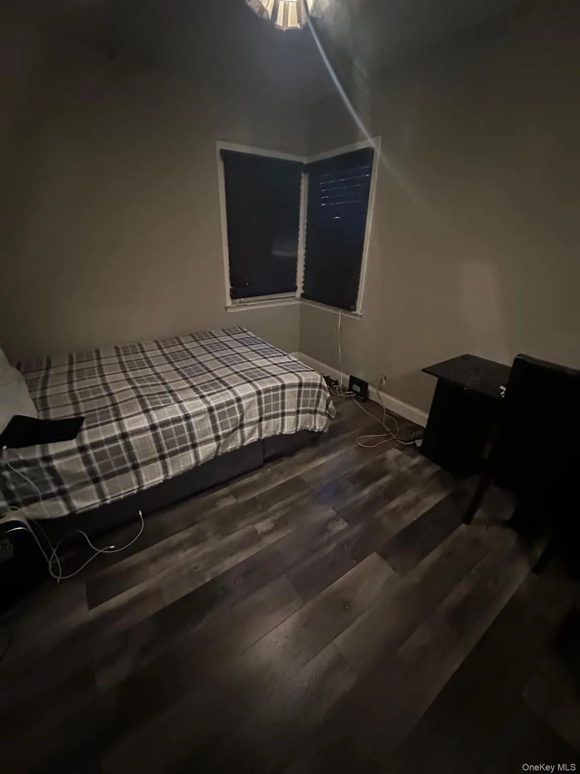 Bedroom featuring dark wood-style flooring and baseboards Bedroom featuring dark wood-style flooring and baseboards