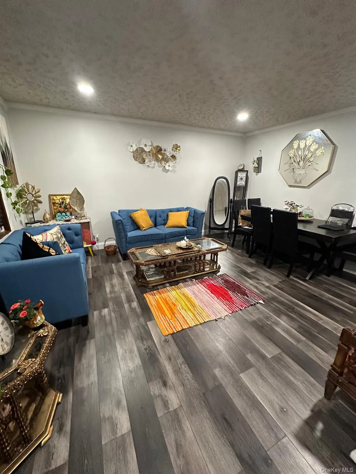 Living room featuring a textured ceiling, dark wood-type flooring, and recessed lighting Living room featuring a textured ceiling, dark wood-type flooring, and recessed lighting